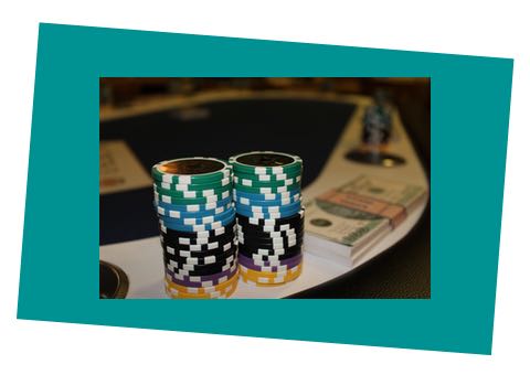 Två staplar med pokermarker och en sedelbunt i bankrulle